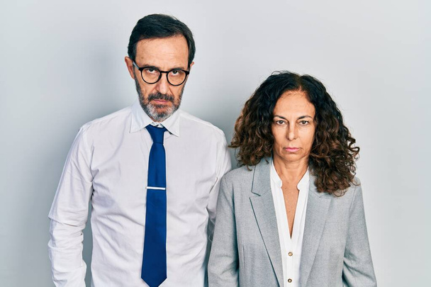 Middle age couple of hispanic woman and man wearing business office uniform skeptic and nervous, frowning upset because of problem. negative person.  - Foto, Imagem