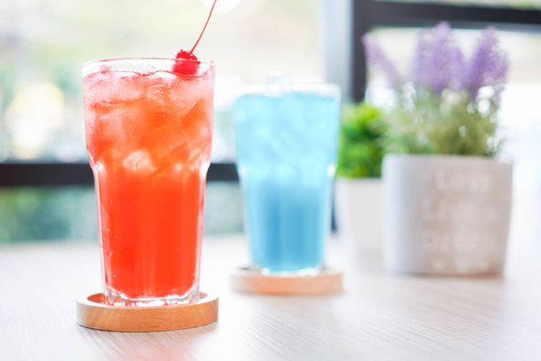 Verfrissende koude drank voor de zomer op ijs. Kleurrijke zomer drankje in hoog glas met houten schotel voor warme dag en feest. - Foto, afbeelding