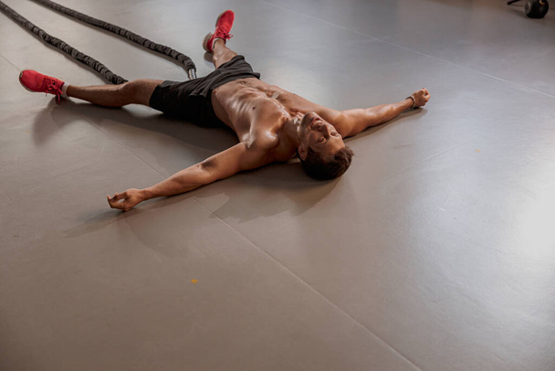 Urheilija treenaa taisteluköyden kanssa kuntosalilla
 - Valokuva, kuva