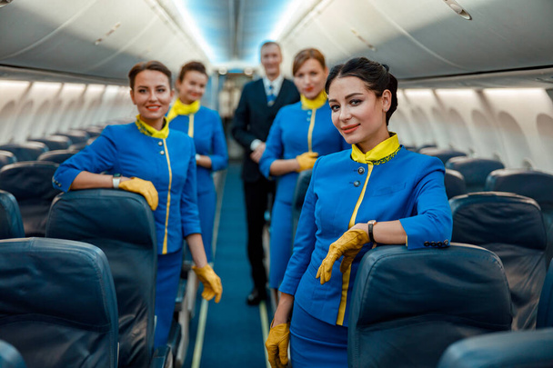 Uçak yolcusu kabininde duran havayolu işçileri - Fotoğraf, Görsel