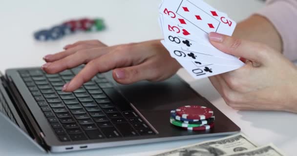 Mujer escribiendo en el teclado del ordenador portátil y la celebración de cartas y fichas de casino primer plano 4k película cámara lenta - Metraje, vídeo