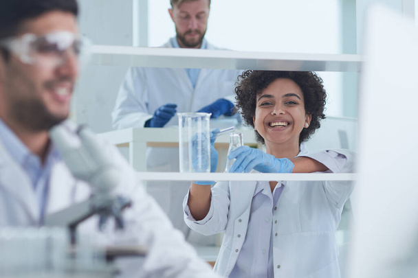 Cientistas sorridentes olhando para os braços da câmera cruzados em laboratório
 - Foto, Imagem