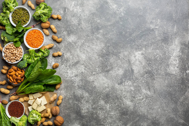 Vejetaryenler için protein: soya peyniri, sebze, fındık, tohum ve baklagiller beton bir arka planda. Kavram: Sağlıklı temiz yiyecekler. - Fotoğraf, Görsel