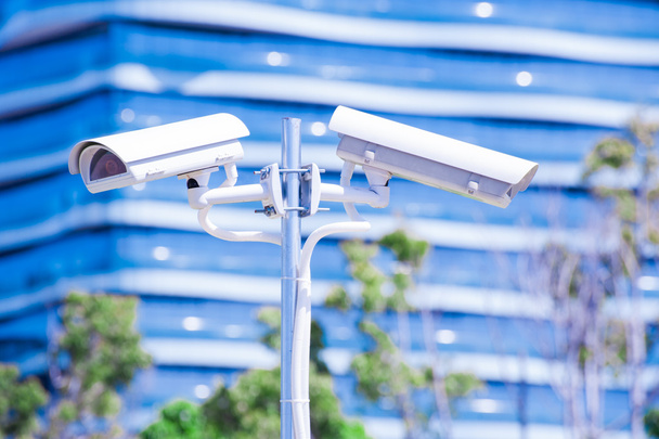 Cámara CCTV o vigilancia operando con edificio azul en bac
 - Foto, imagen