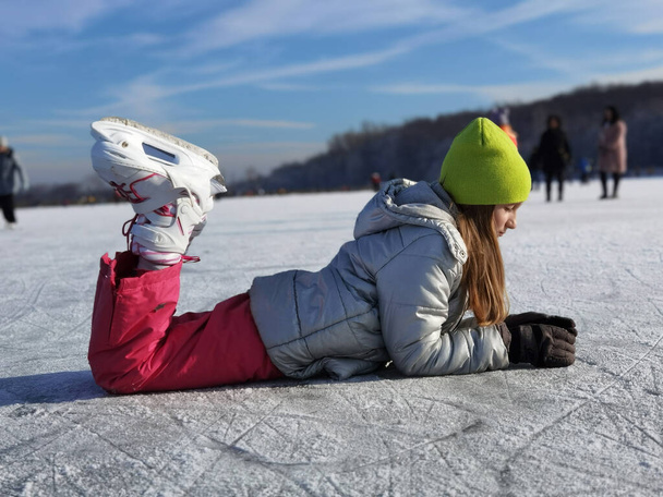 Liebenswertes kleines Mädchen beim Schlittschuhlaufen auf der Eisbahn - Foto, Bild