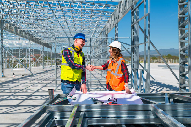 Mérnök két ember kézfogás megállapodás projekt épület építése, Kézfogás az építési területen - Fotó, kép