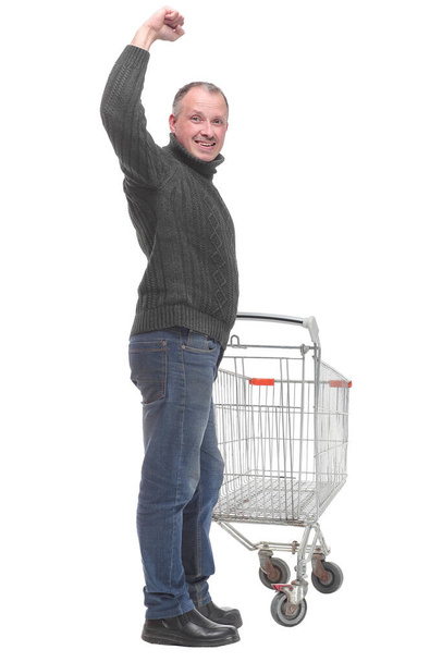 Man wearing sweater and jeans pushing an empty shopping cart - Foto, afbeelding