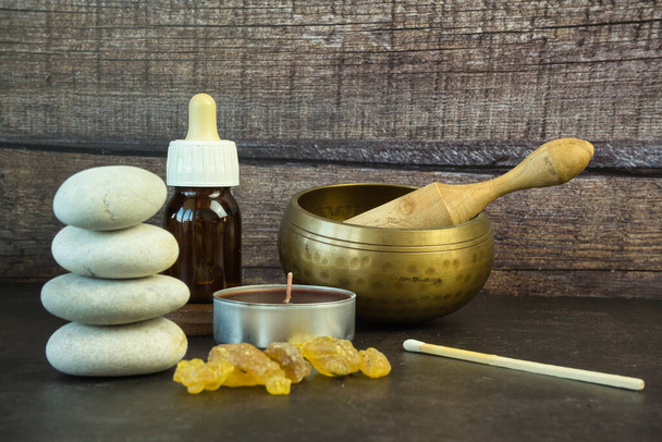 Frankincense resin, Tibetan singing bowl, essential oil on a dark background. Spa, wellness and beauty concept. - Fotografie, Obrázek