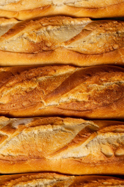 Un fondo de primer plano de pequeñas baguettes de pan francés. - Foto, imagen