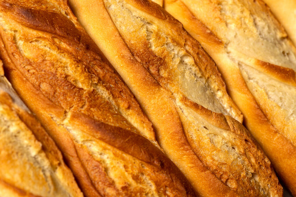 Uno sfondo primo piano di baguette di pane francese più piccole. - Foto, immagini