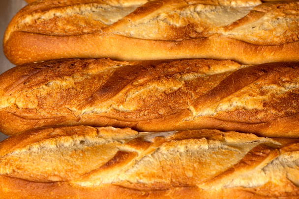 Un fondo de primer plano de pequeñas baguettes de pan francés. - Foto, imagen