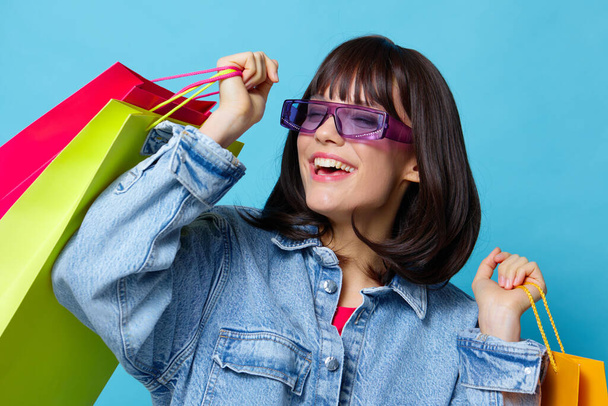 giovane donna in occhiali da sole shopping emozioni posa gioia isolato sfondo - Foto, immagini