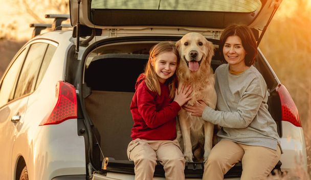 Family with golden retriever dog in car - Фото, изображение