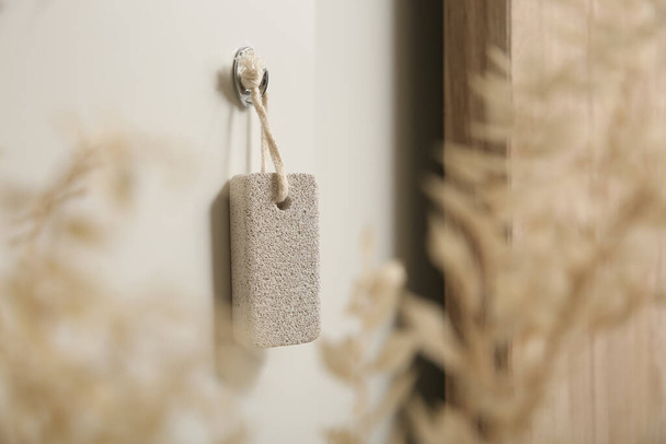 Pumice stone hanging on white wall indoors - Fotoğraf, Görsel