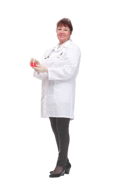 Side view of woman doctor dark hair in medical coat or scientist holding beaker with red liquid - Foto, afbeelding