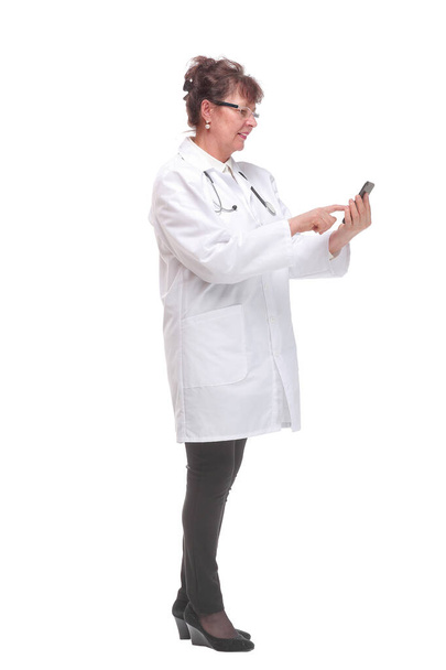 Side view of female doctor holding smartphone answering to patients over white background - Fotó, kép