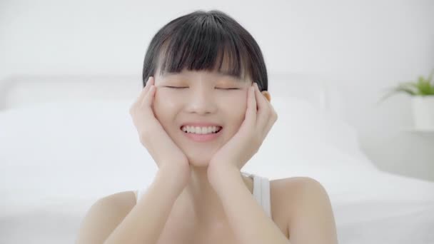 Mooie jonge aziatische vrouw make-up van cosmetische, meisje hand aanraken wang op gezicht en glimlachen aantrekkelijk, gezicht van schoonheid perfecte huidverzorging met wellness en rimpel, huidverzorging en gezondheid concept. - Video