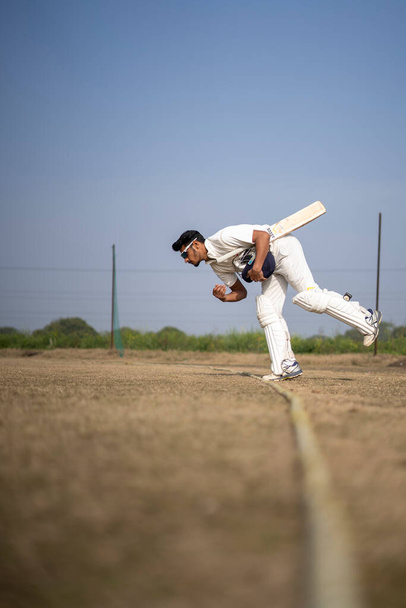 Junge indische Cricketspieler betreten das Cricketfeld. Indisches Cricket und Sportkonzept. - Foto, Bild