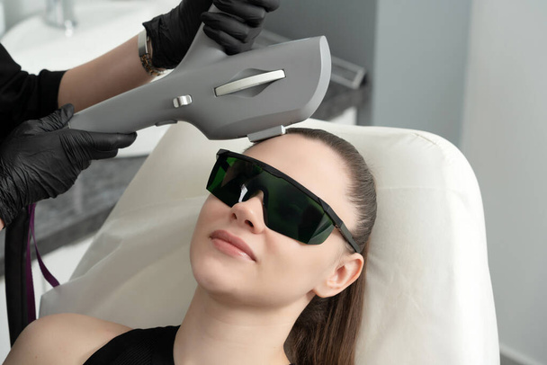 Młoda kobieta leczona laserowo w klinice kosmetologii - Zdjęcie, obraz