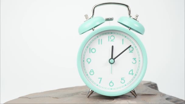 Time lapse, el despertador azul dice la hora. Rotación rápida en sentido horario sobre fondo blanco. - Imágenes, Vídeo