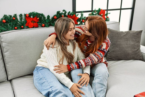 Nő pár ölelés egymást ül a karácsonyi dekoráció otthon - Fotó, kép