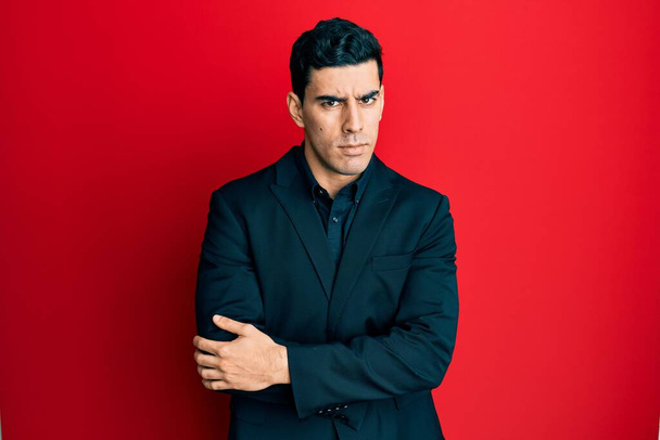 Handsome hispanic man wearing business clothes skeptic and nervous, disapproving expression on face with crossed arms. negative person.  - Photo, Image