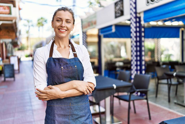 Beautiful blonde woman waitress standing at restaurant smiling happy - Φωτογραφία, εικόνα