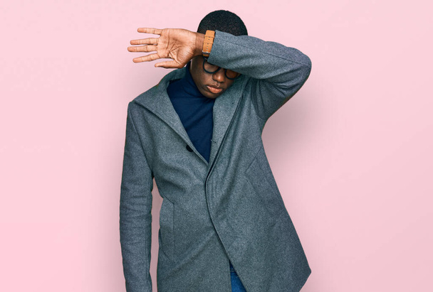 Young african american man wearing business clothes and glasses covering eyes with arm, looking serious and sad. sightless, hiding and rejection concept  - Photo, Image