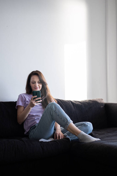The morning routine of a young woman using her phone. - Foto, Bild