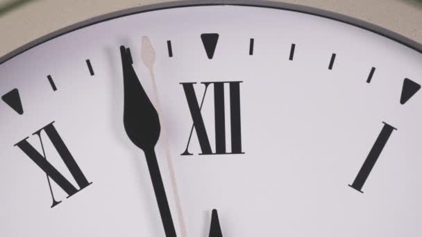 Die weiße Wanduhr zeigt die Uhrzeit 12 Uhr an. Es ist Zeit, eine Pause einzulegen und zu essen. - Filmmaterial, Video