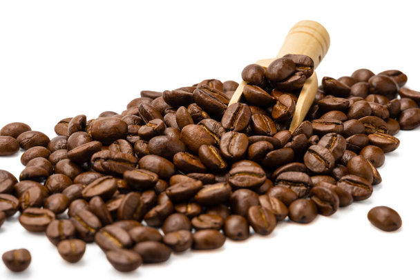 Смажені кавові зерна з маленькою дерев'яною ложечкою ізольовані на білому тлі, селективний фокус
 - Фото, зображення