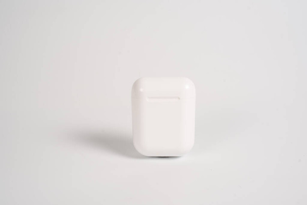 white earphones in a case on a white background - Foto, Imagem
