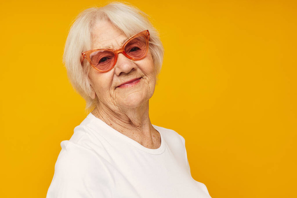 Portrait d'une vieille femme amicale en t-shirt décontracté et lunettes gros plan émotions - Photo, image