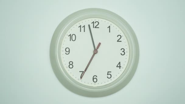 Horloge murale blanche dit 2 minutes jusqu'à 7 heures du matin. Le temps passait lentement en un jour. sur fond blanc. - Séquence, vidéo
