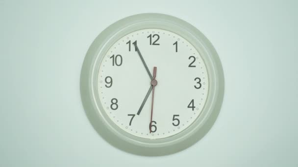 Orologio da parete bianco dice 4 minuti a ore 7. Il tempo passò lentamente in un giorno su sfondo bianco. - Filmati, video