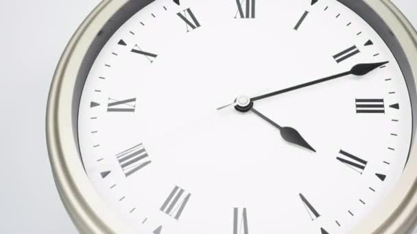 Silver wall clock tells time at 5 o'clock. Time passed quickly in a day on white background. - Footage, Video
