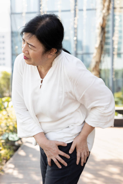 vieille femme âgée asiatique malade souffrant de douleur pelvienne, raideur de la hanche, goutte, rhumatoïde, symptômes d'ostéoporose - Photo, image