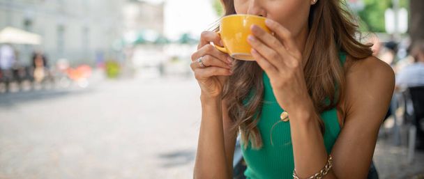 Portrait of a beautiful woman drinking from a cup - Photo, Image