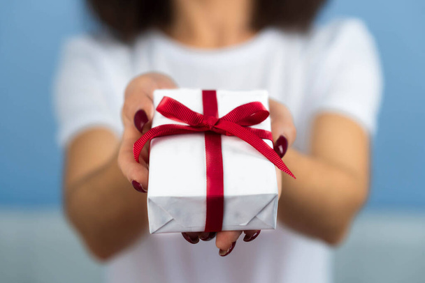 День Святого Валентина. Женские руки красотки держат коробочку подарка обернутую бумагой с лентой - Фото, изображение