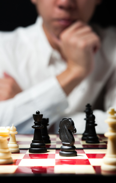 Uomo su camicia bianca giocare a scacchi pensare per strategia business con
 - Foto, immagini