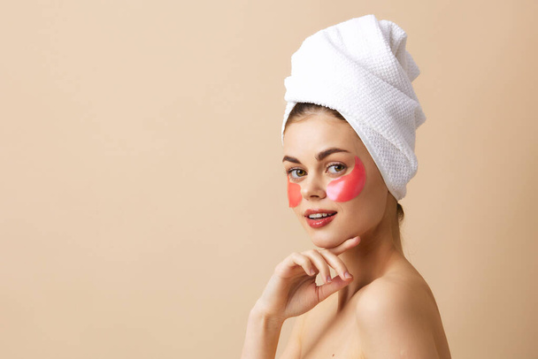 pretty woman skin care face patches bare shoulders beige background - Foto, Bild