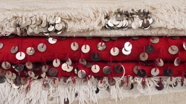 Tradycyjna marokańska tkanina plemienia Berber w kolorze beżowym, białym i czerwonym, z pailletami, cekinami. Używany jako koc ślubny, rzucać, tkanina, narzuta, suknia ślubna Berber. Materiał 4k. - Materiał filmowy, wideo