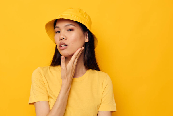 Charming young Asian woman in a yellow t-shirt and hat posing emotions Lifestyle unaltered - Фото, зображення