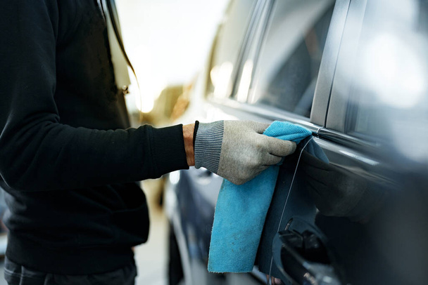 Close up of male car service worker applying nano coating on a car - Фото, изображение