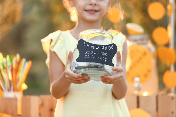 Милая девушка продает лимонад в парке - Фото, изображение