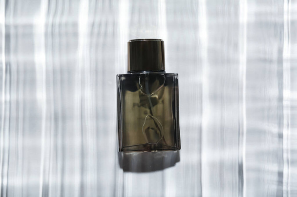 Bottle of perfume for men in water on light background - Foto, afbeelding
