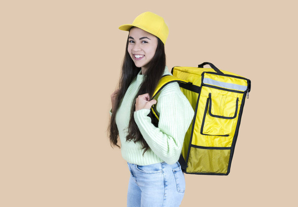 hispanic delivery woman with backpack, beige background - Foto, immagini