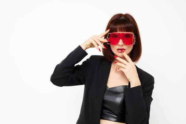 attractive woman in red with stylish glasses a leather suit black jacket light background - Fotoğraf, Görsel