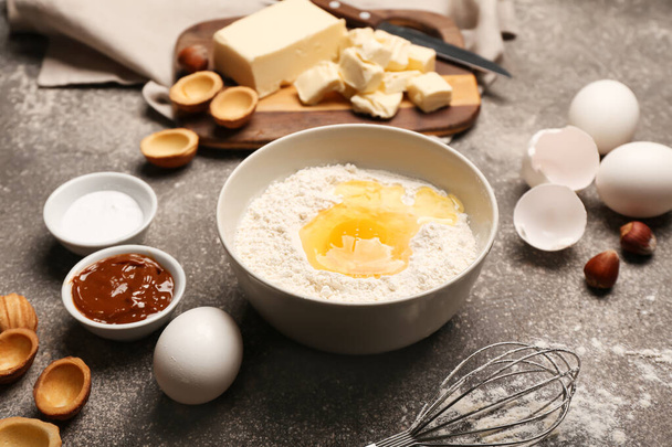 Świeże składniki do przygotowywania ciasteczek w kształcie orzecha włoskiego z gotowanym mlekiem skondensowanym na szarym tle - Zdjęcie, obraz