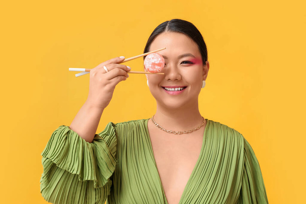 Beautiful Asian woman with tasty Japanese mochi on color background - Foto, imagen